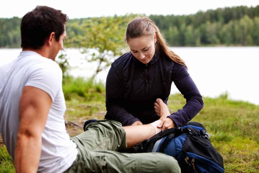 Wilderness First Aid Basics 1 Woman applying first aid to man in the wilderness.