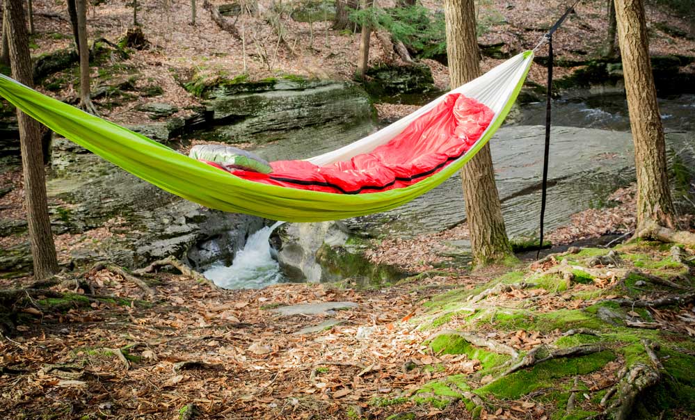 Hammock Camping - Green Hammock with red sleeping bag. 