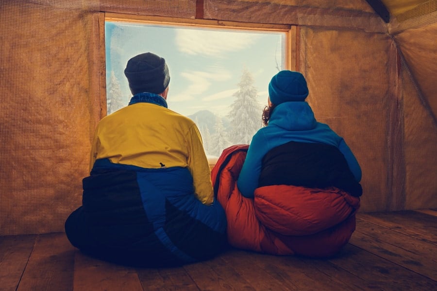The Ultimate Guide to Winter Camping 1 Two Campers Sit in Winter Sleeping Bags