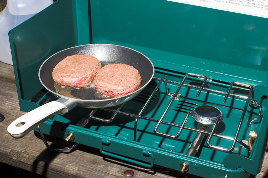 Cooking hambrugers on a camp stove