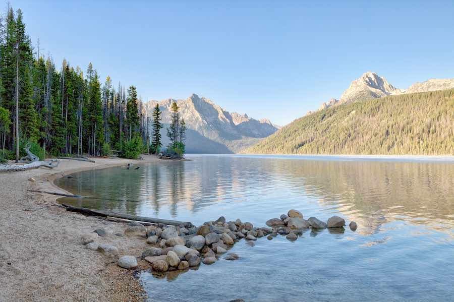 Trees, beach, water, and mountains at Redfish Lake in Idaho