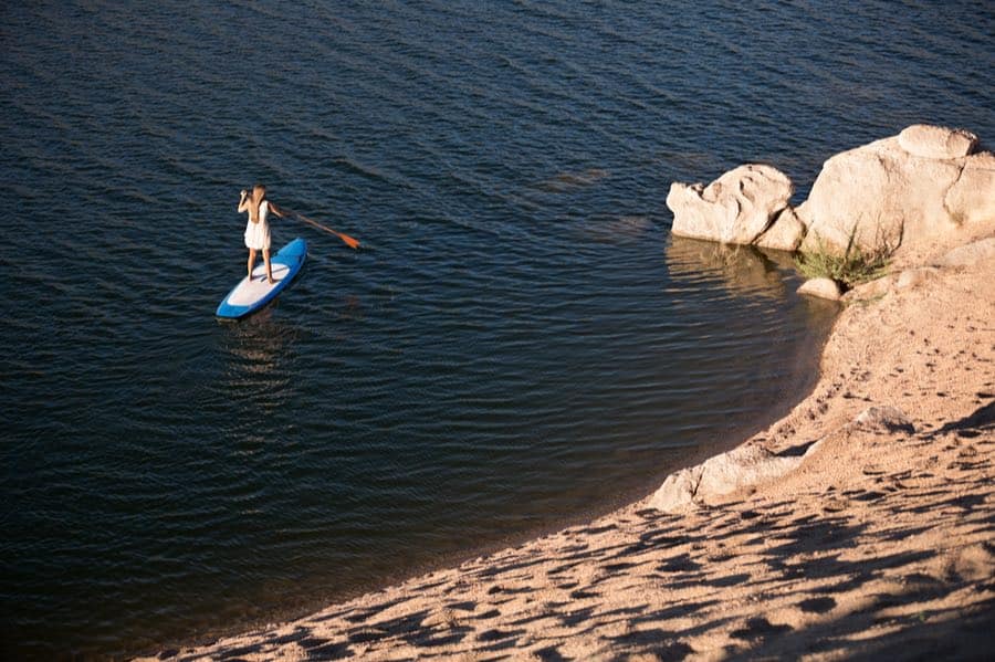Ultimate Beginner’s Guide to Stand Up Paddleboarding (SUP) 5 Woman On SUP Near Shore