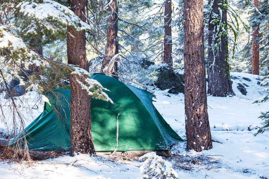 Photo of green camping tent in the winter.