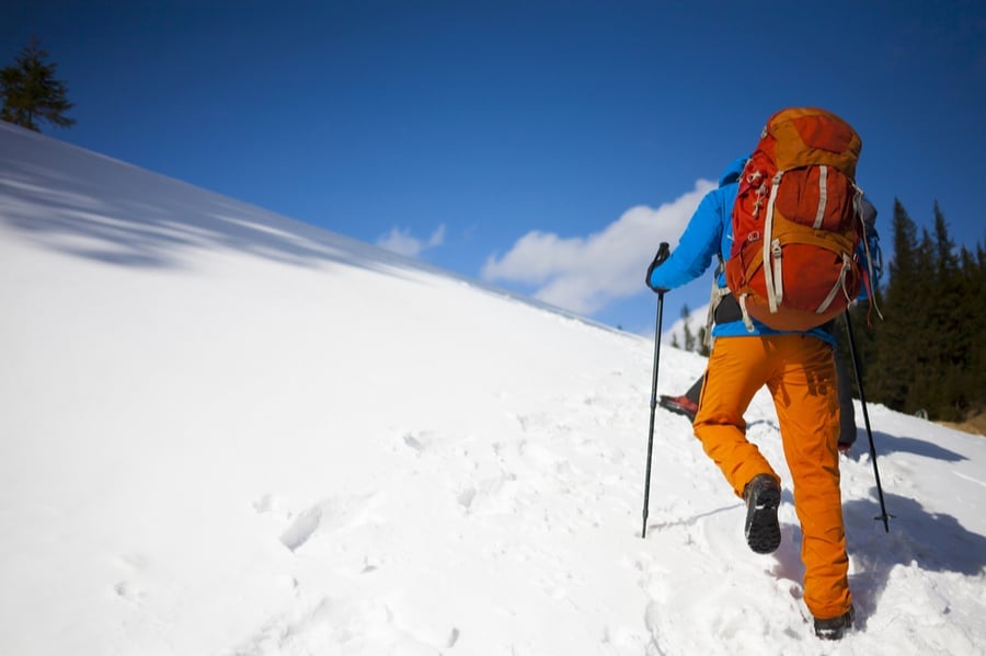 Winter Backpacker Hiking Uphill in Snow