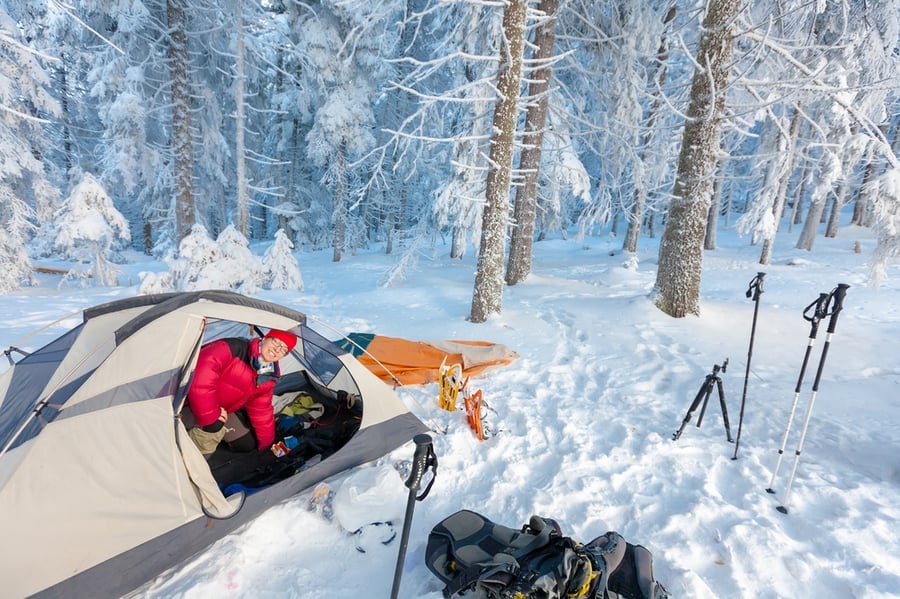 Woman Looking Out of Winter Tent in the Snow