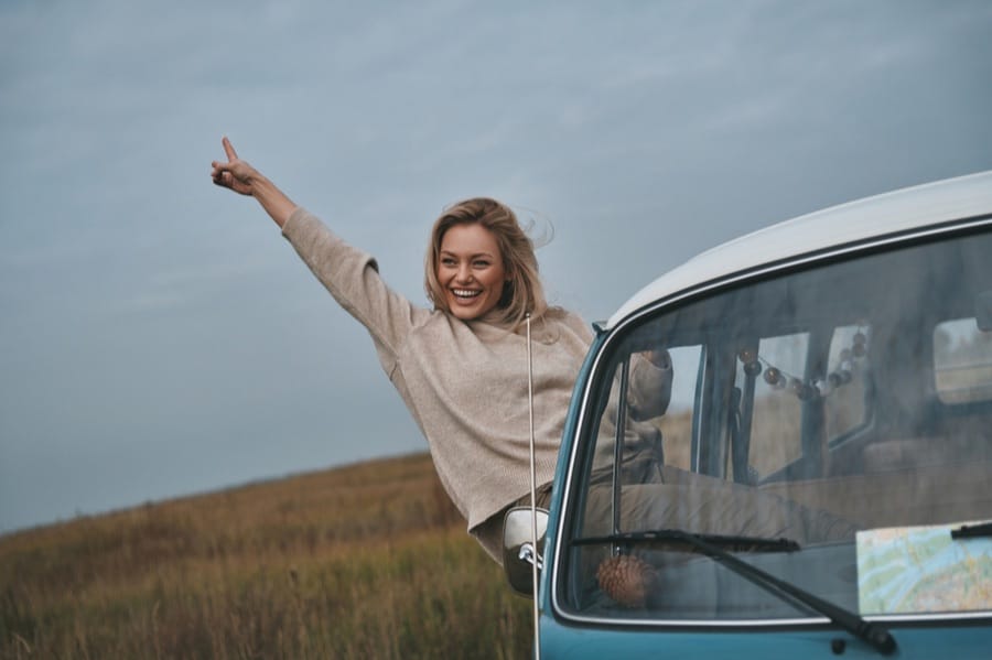 woman hanging out of window in camper van