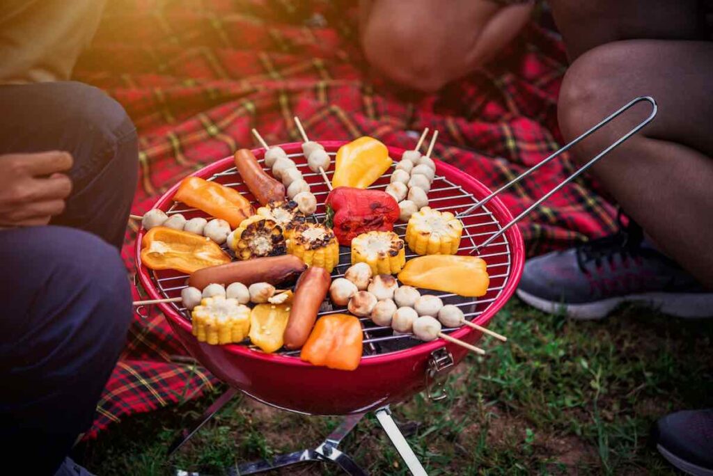 Grilling skewers of food on a small charcoal grill.