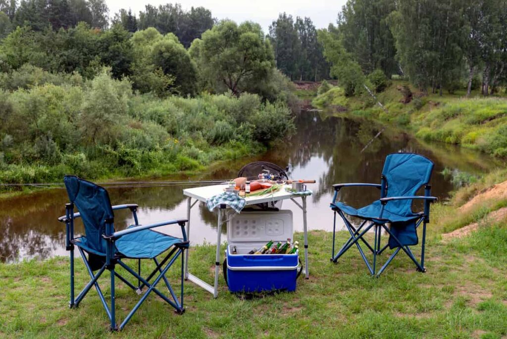 The 7 Best Camping Chairs for 2023 9 Camping chairs, a portable table, and a cooler by a river.