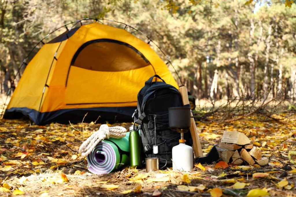 Basic camping trip gear: tent, sleeping mat, daypack, hiking accessories.