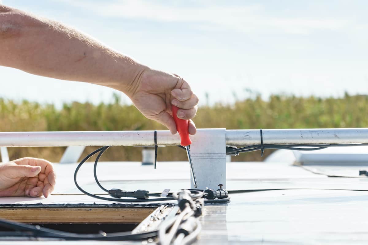 RV Maintenance 101: A Comprehensive Guide to Keeping Your Home on Wheels in Top Shape 2 Man making repairs around an RV vent.