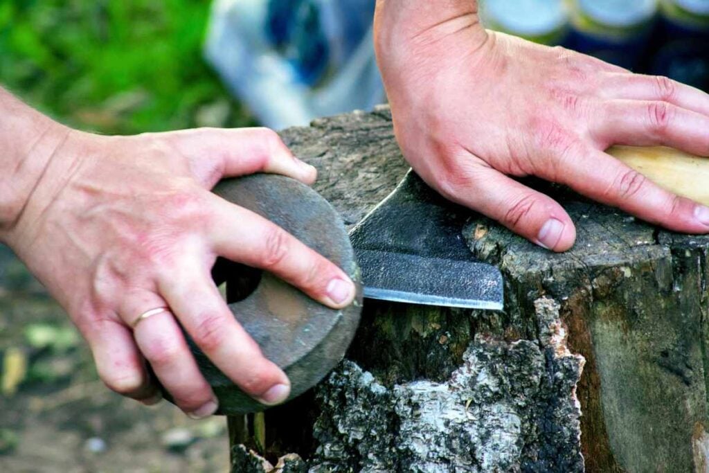 The Best Camping Axe: Our Top 4 Picks 7 Sharpening a camping axe blade.