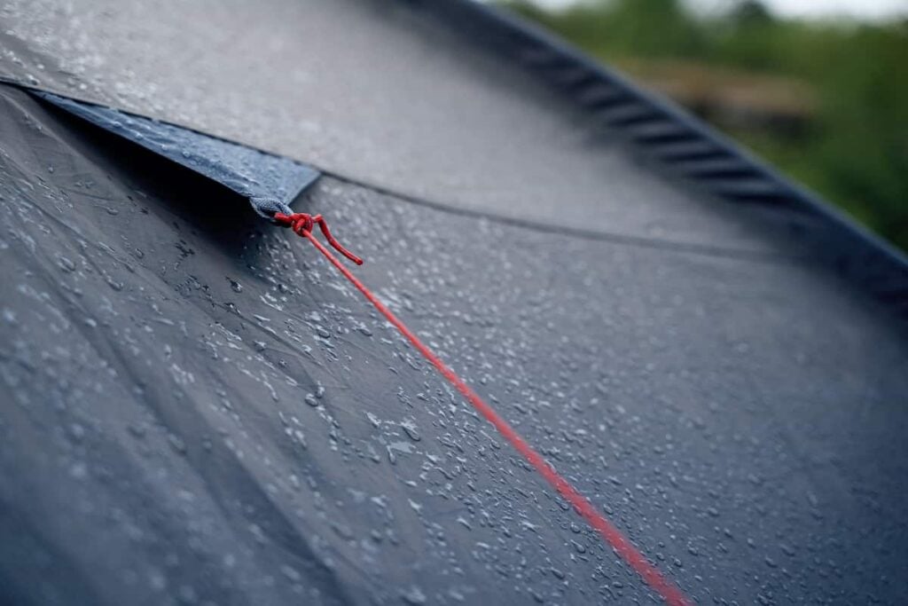 Closeup of a camping tent during a rainstorm.