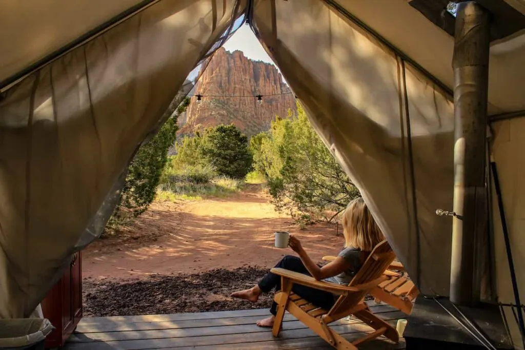 The 12 Best Spots for Glamping in the Grand Canyon 1 A woman sitting on a deck enjoying glamping Grand Canyon-style.