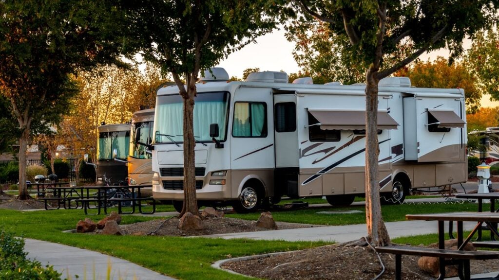 An RV motorhome with slides out and awnings up.