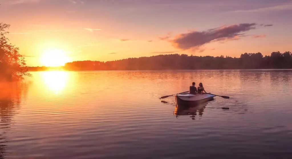 Clear Lake State Park Camping Guide 1 A couple in a boat on a lake enjoying a beautiful sunset.