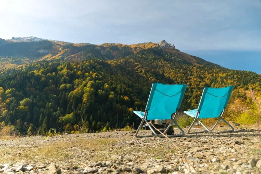 The Best Lightweight Camping Chair for 2023: Our Top 5 Picks 7 Two blue folding camping chairs set up to enjoy a mountain view.