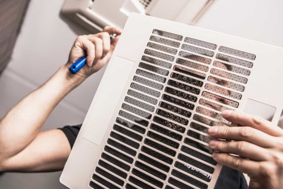 RV Maintenance 101: A Comprehensive Guide to Keeping Your Home on Wheels in Top Shape 4 A man cleaning an RV air filter.
