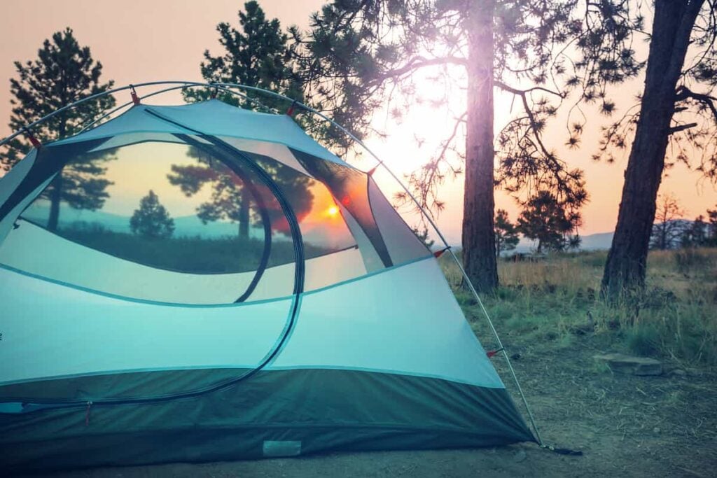 A tent campsite at sunrise or sunset.