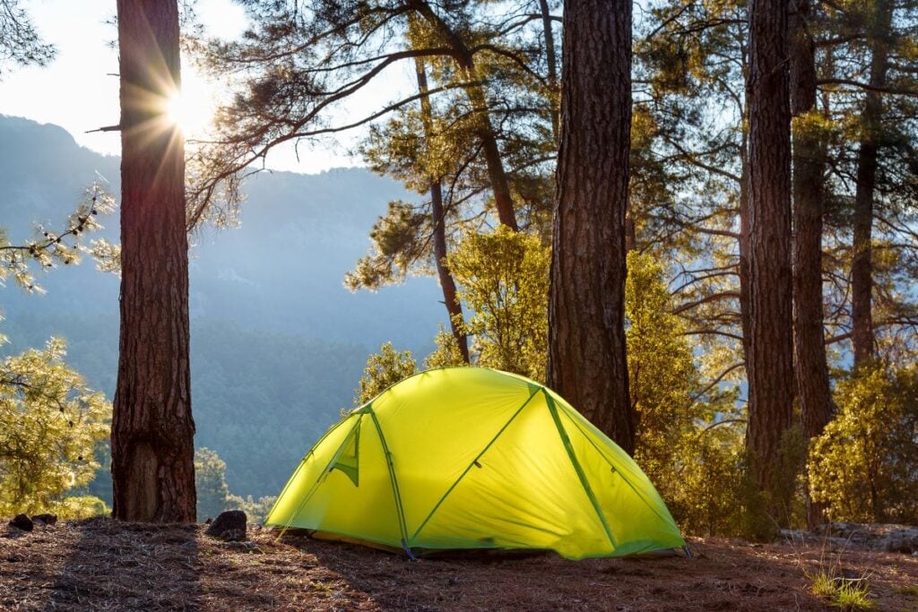 A tent set up in a primitive mountain camping spot.