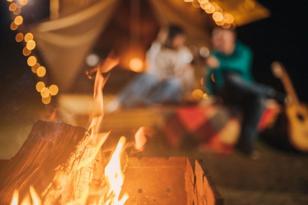 The 13 Best Destinations for Glamping in Arizona 2 A couple enjoying luxury glamping at night near a fire.