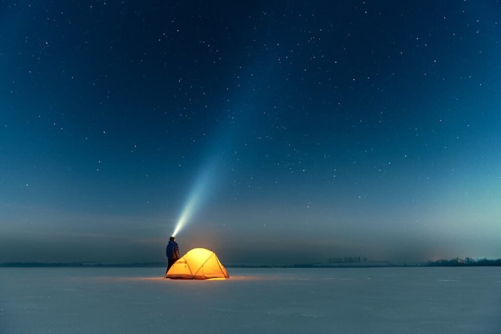 A camper in winter wearing a headlamp.