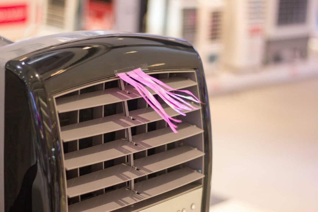 Closeup of tassels taped to the front of a small air conditioner. Best camping air conditioners.