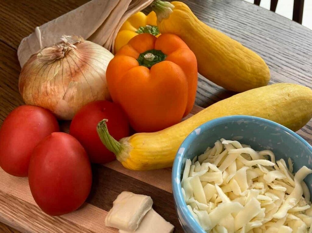 Ingredients for vegetable quesadillas -- vegetables, cheese, tortillas, and butter.