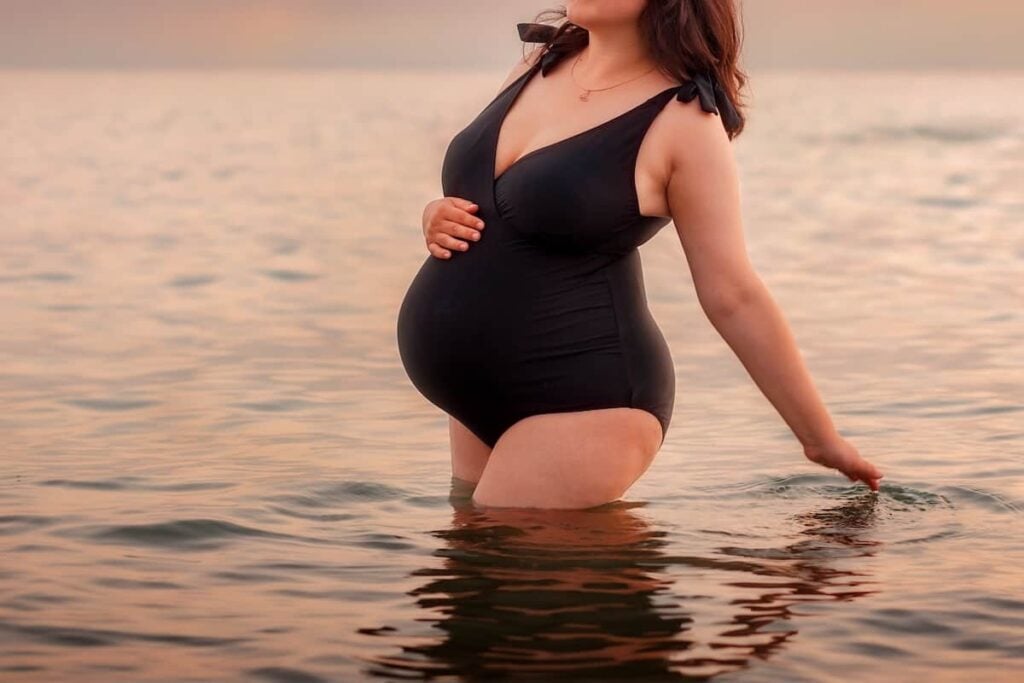 A pregnant woman wading in water.