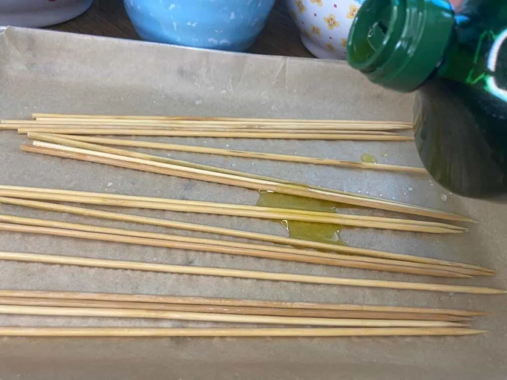 Grilled Veggie Kabobs: A Colorful and Healthy Camping Side Dish 9 Pouring olive oil onto skewers.