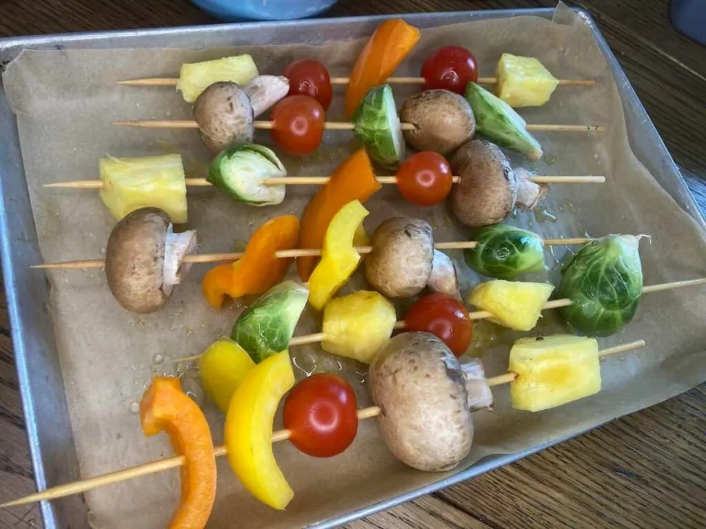 Grilled Veggie Kabobs: A Colorful and Healthy Camping Side Dish 10 Assembled veggie kabobs on parchment-lined tray.
