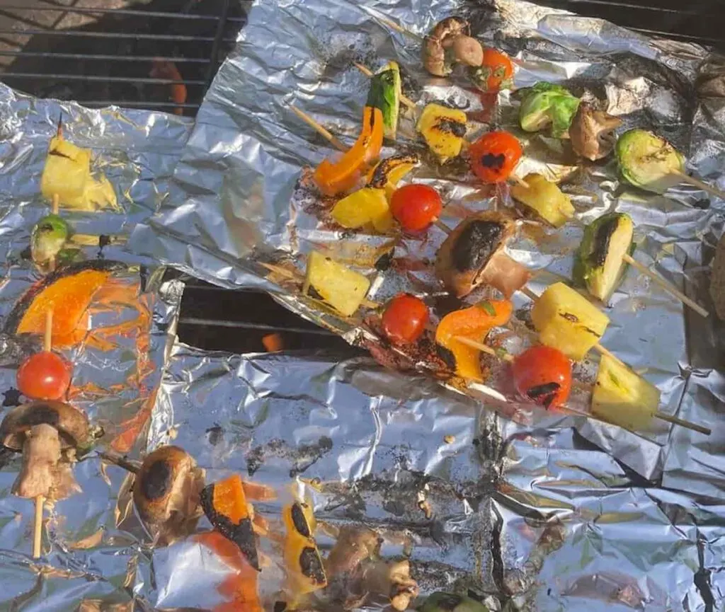Grilled Veggie Kabobs: A Colorful and Healthy Camping Side Dish 13 Veggie kabobs grilled on foil over campfire .