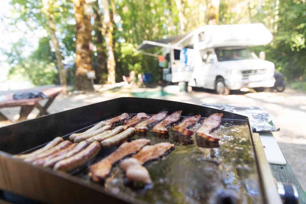 Cooking bacon and sausage on the best portable grill
