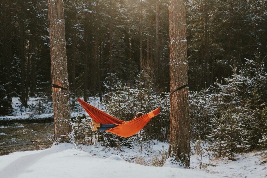 The Ultimate Guide To Hammock Underquilts: Cozy Comfort For Hammock Camping 4 Red hammock in snowy landscape.