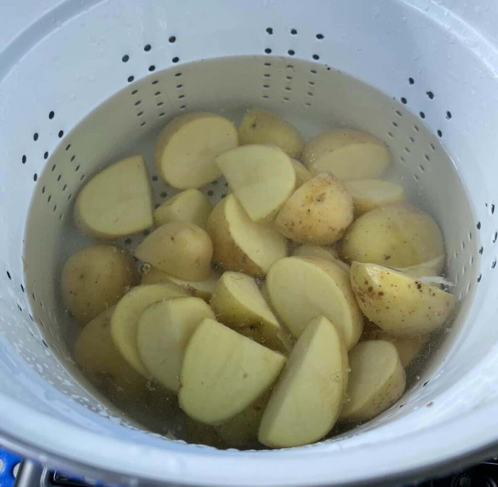How to Make Campfire Potatoes 5 Potatoes covered with water in a pasta pot.