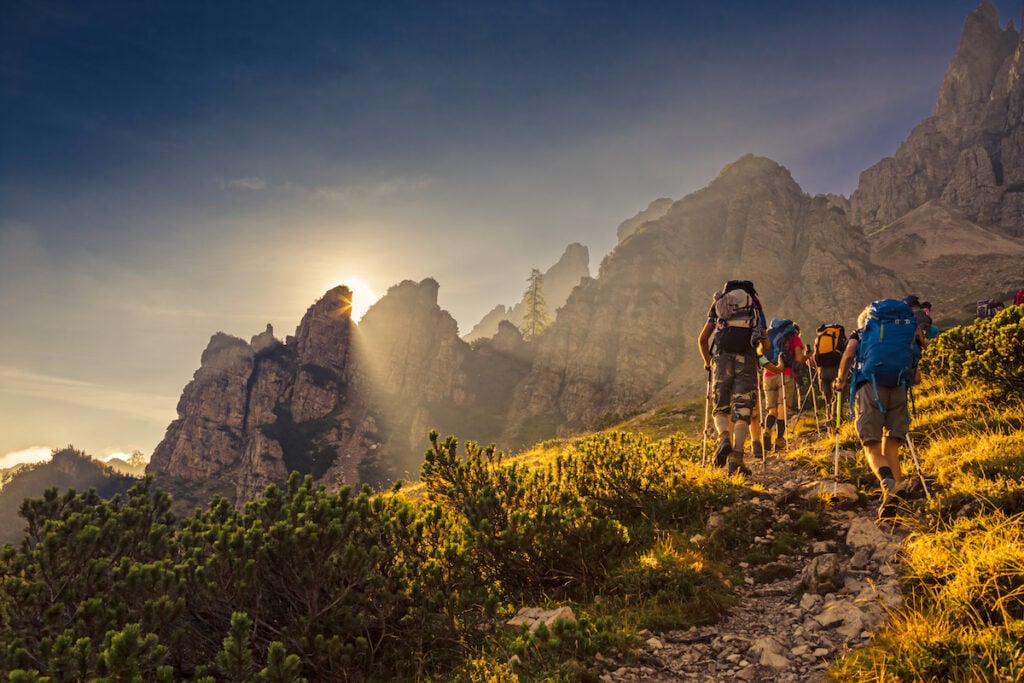 Some hikers go up a mountain path in the early hours of the day