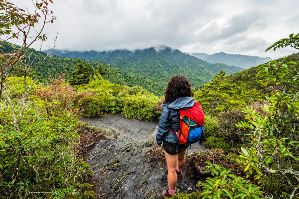 Woman hikes by beautiful cloudy overlook in the Great Smoky Mountains National Park