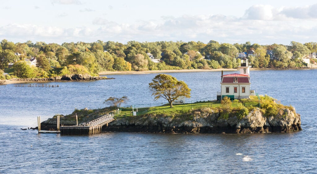 House-lighthouse on a lonely island in the bay near the coast.